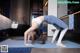 A woman doing a yoga pose on a blue mat.