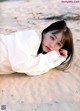 A woman laying on the sand on a beach.