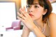 A woman sitting at a table with her hand on her face.