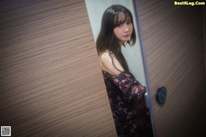 A woman standing in front of a mirror in a room.