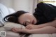 A woman laying on a bed with her head on a pillow.