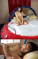 A naked woman sitting on top of a bed.