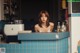 A woman sitting at a counter in a kitchen.